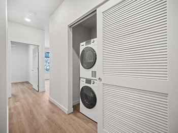 a white laundry room with a washer and dryer on the wall